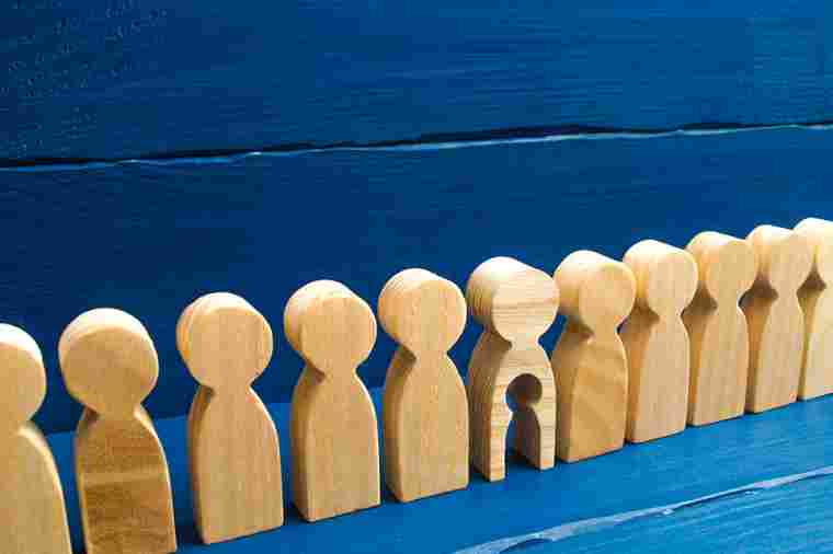 © Andrii Yalanskyi - stock.adobe.com Holzfiguren in einer Reihe, eine hat ein ausgeschnittenes Kind