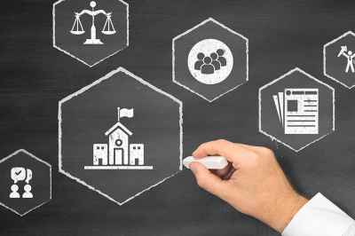 Person malt Zeichen auf Tafel mit Kreide