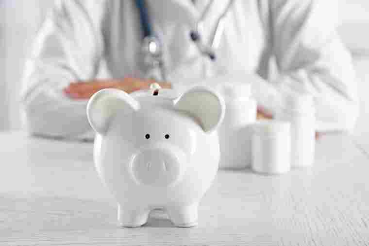 © Africa Studio - stock.adobe.com Arzt hinter Sparschwein